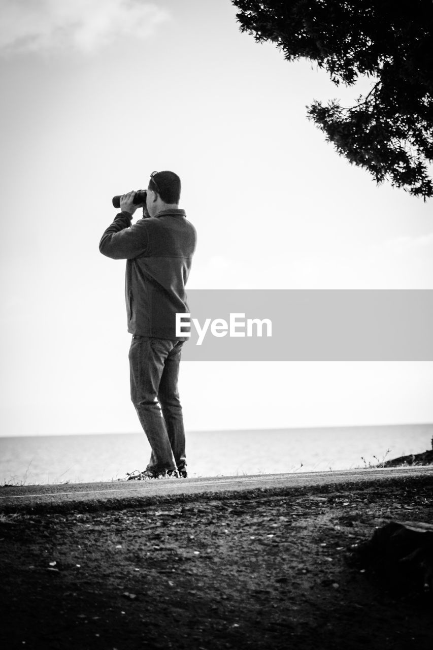 WOMAN STANDING ON BEACH