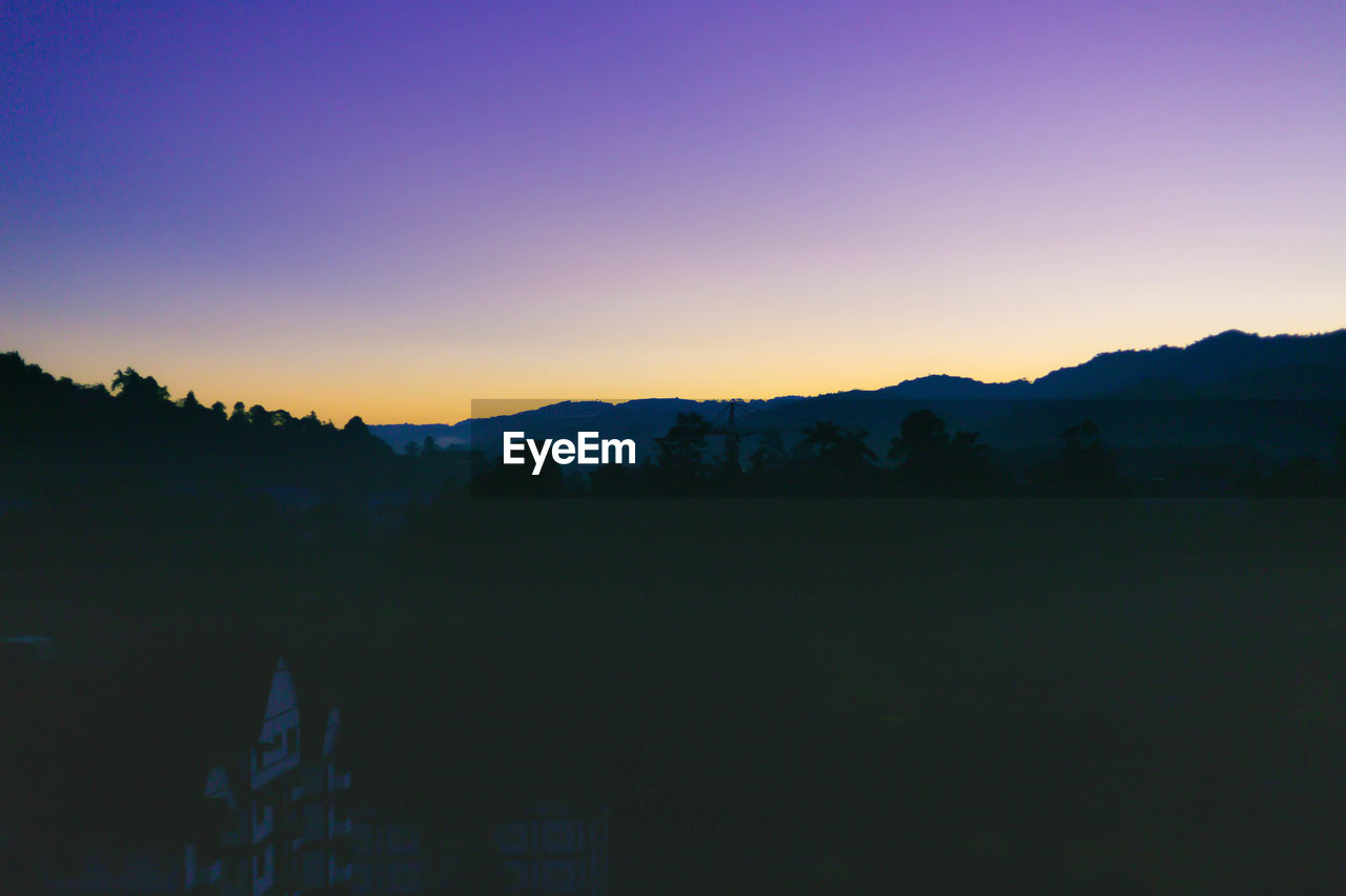 SILHOUETTE LANDSCAPE AGAINST CLEAR SKY DURING SUNSET