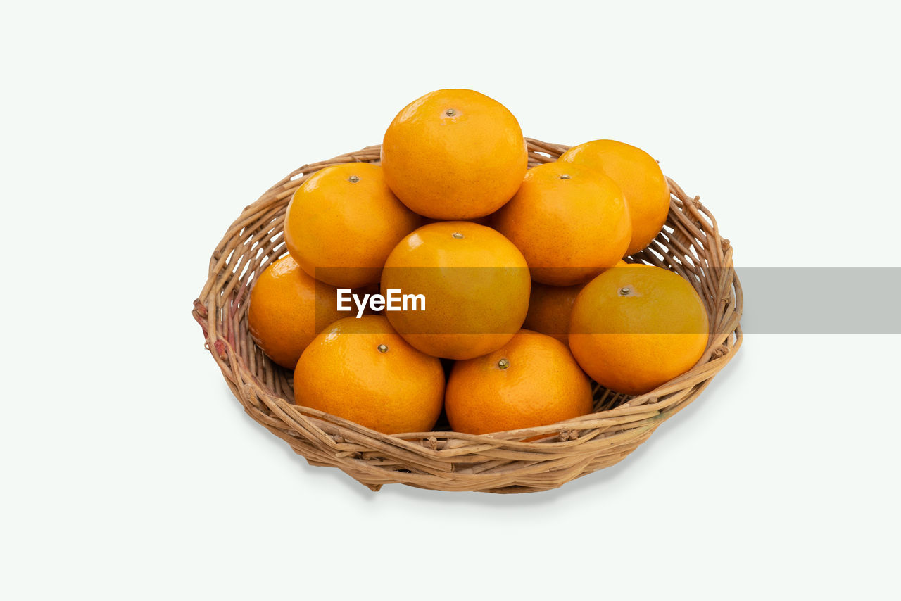 high angle view of oranges in basket on white background