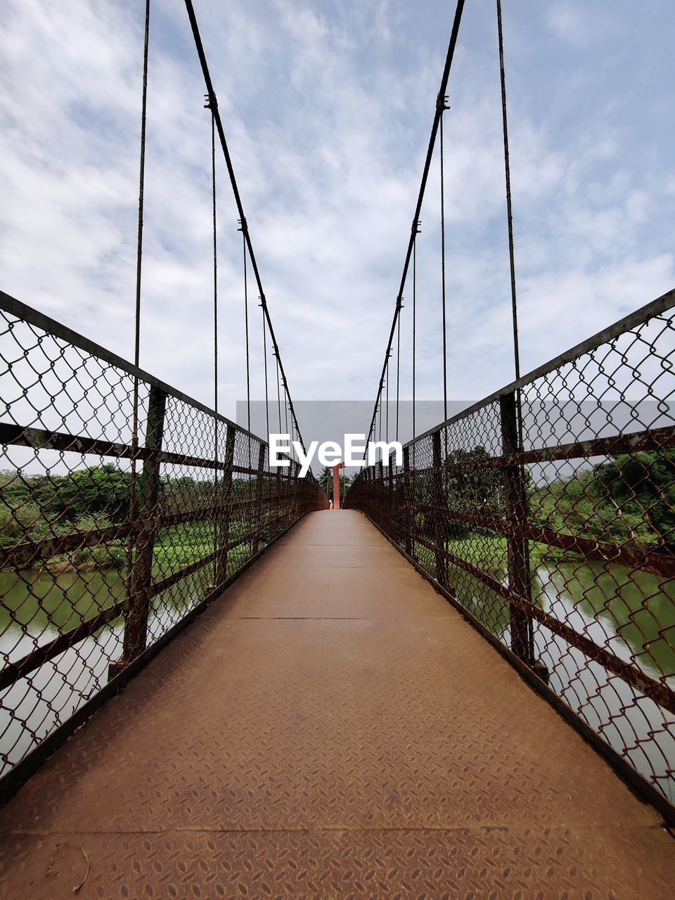 View of hanging iron bridge against sky