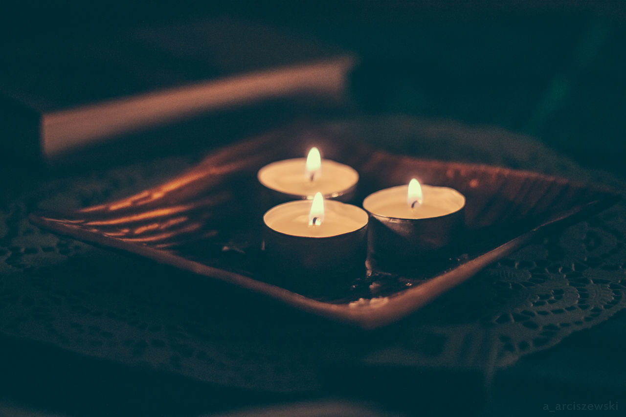 Close-up of lit tea light candles on table