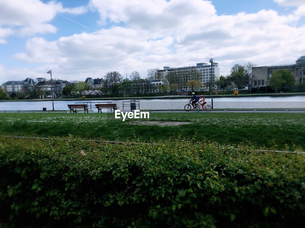 People riding bicycle on road against sky