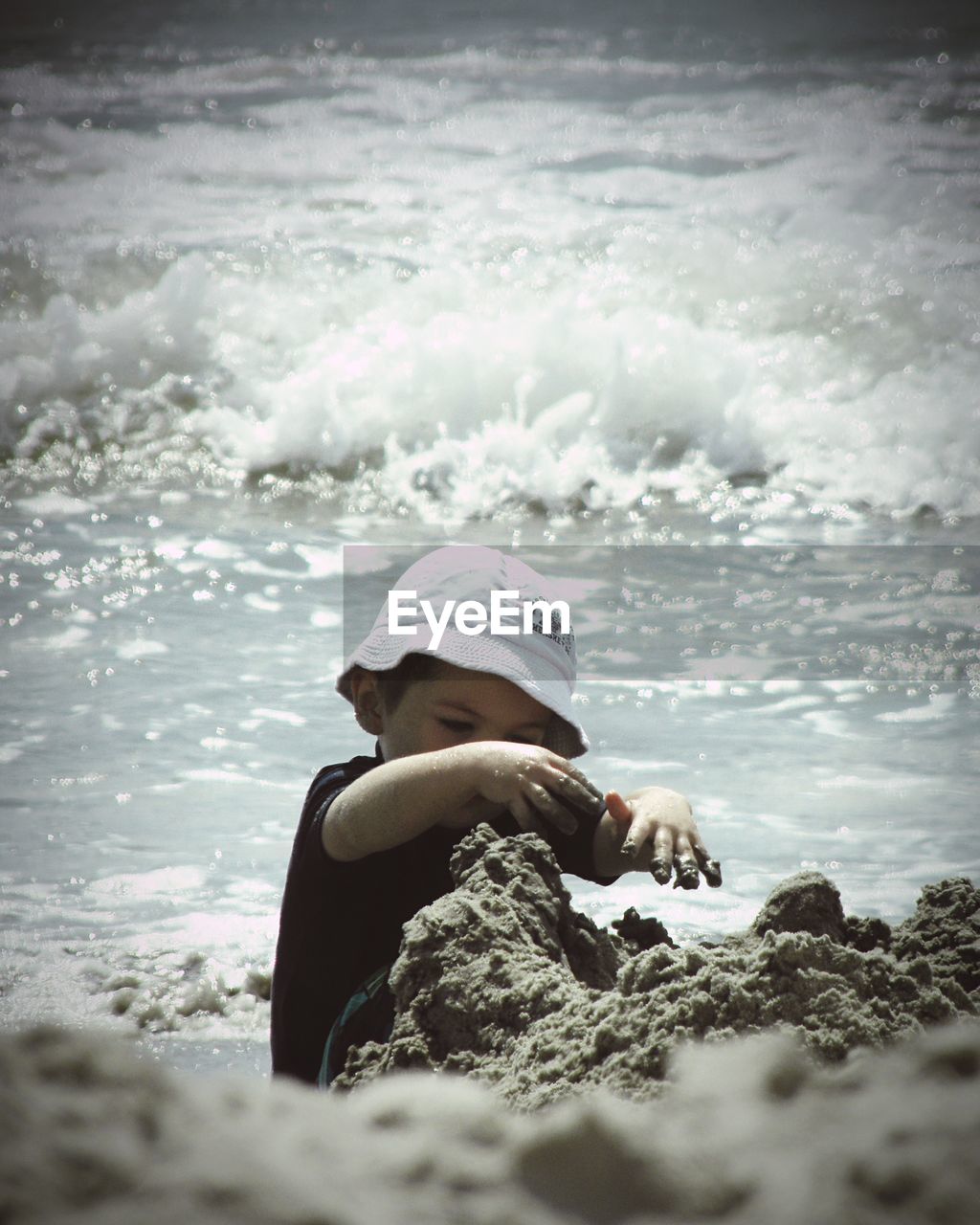 REAR VIEW OF MAN STANDING ON BEACH