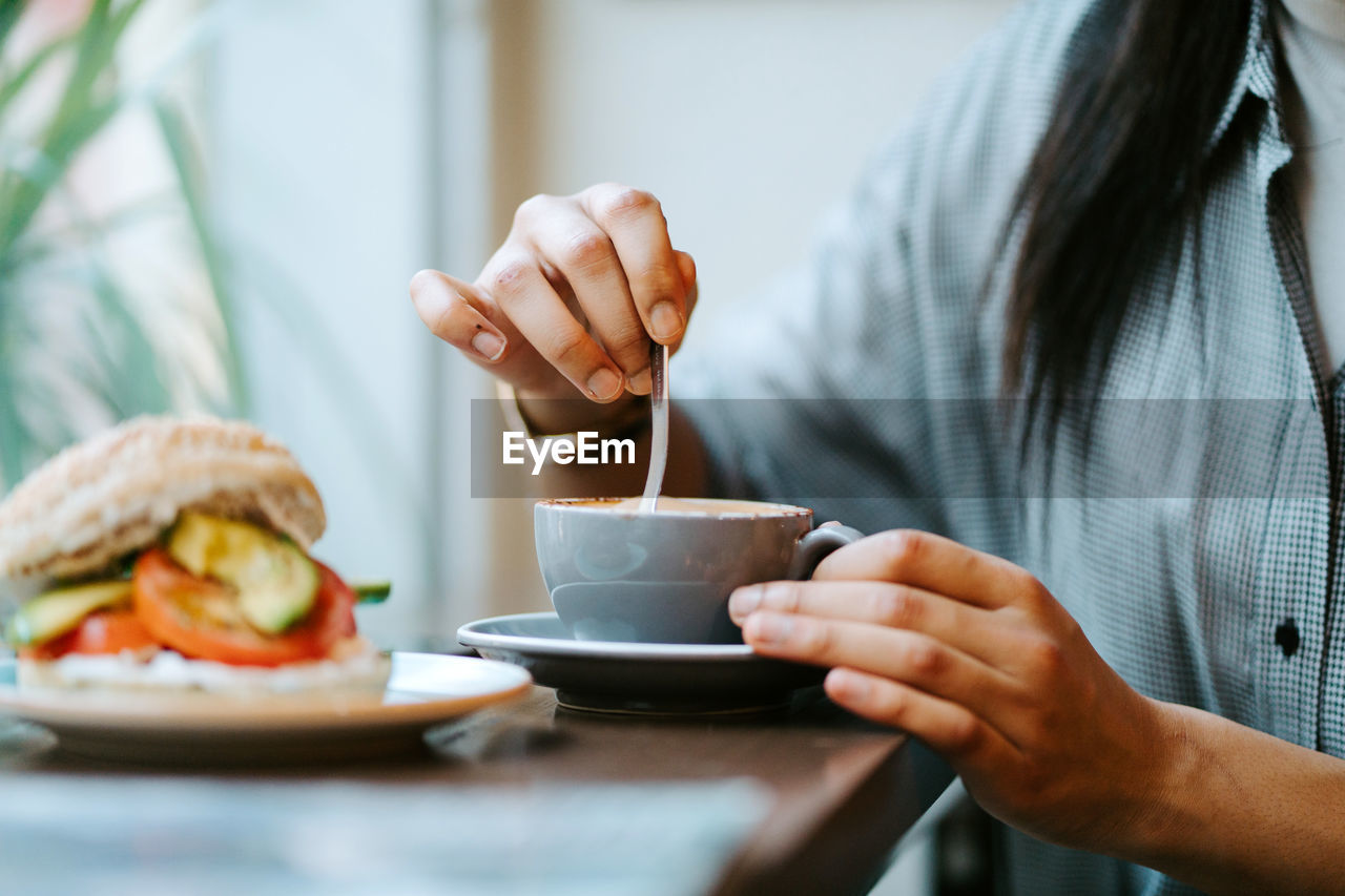 Woman drinking a cup of coffee in a coffee shop