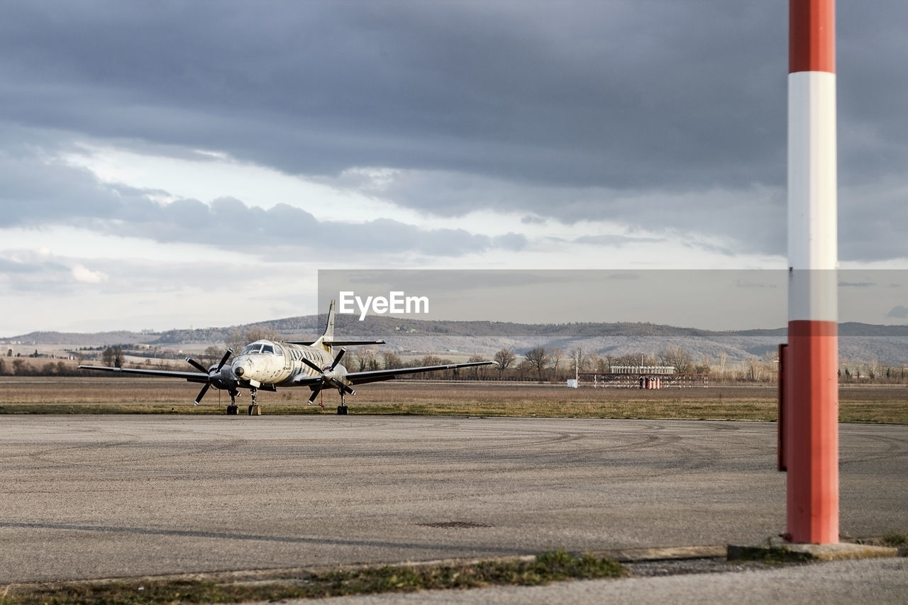 Airplane on airport runway against sky