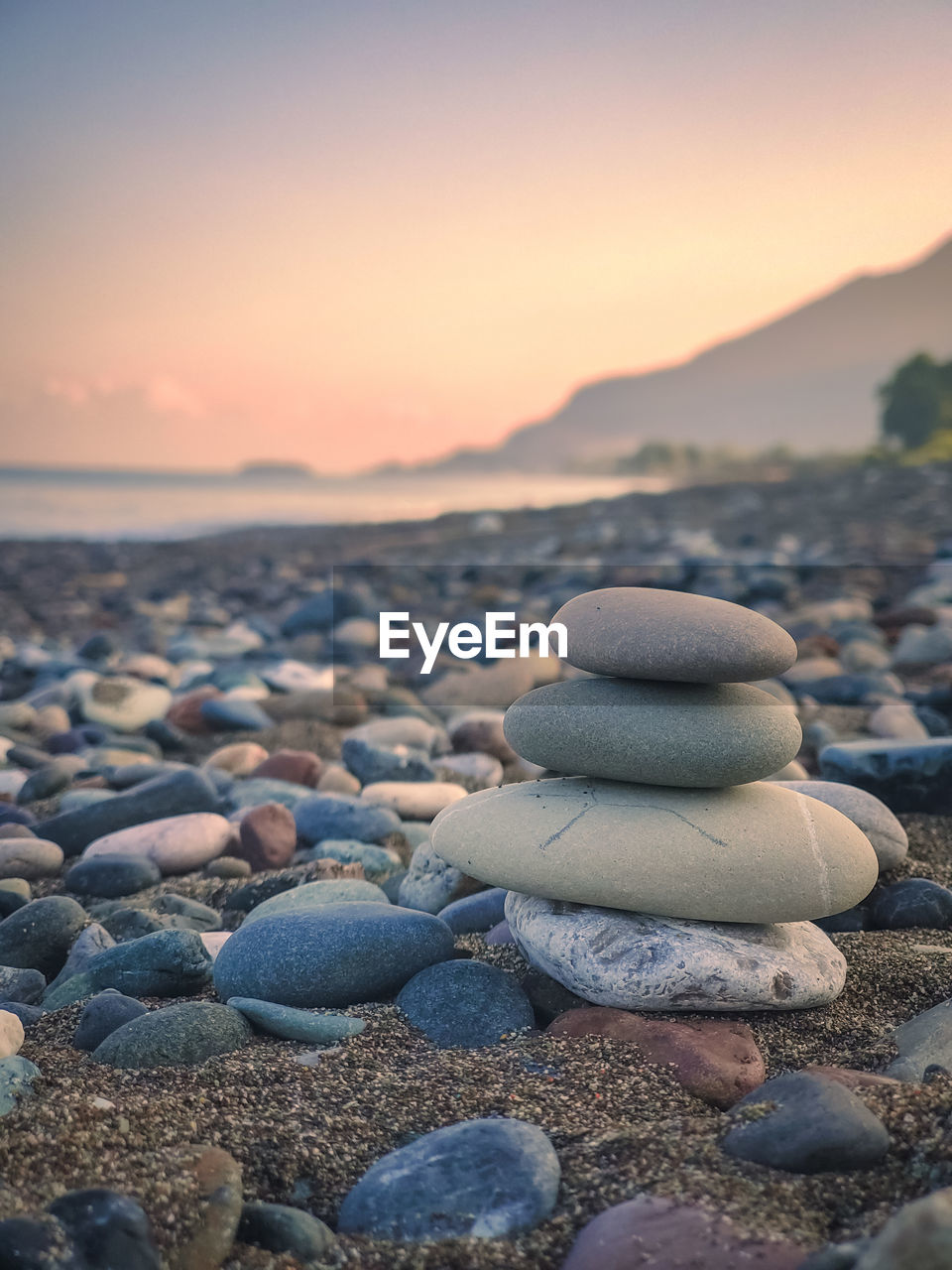 close-up of rocks on beach against sky during sunset