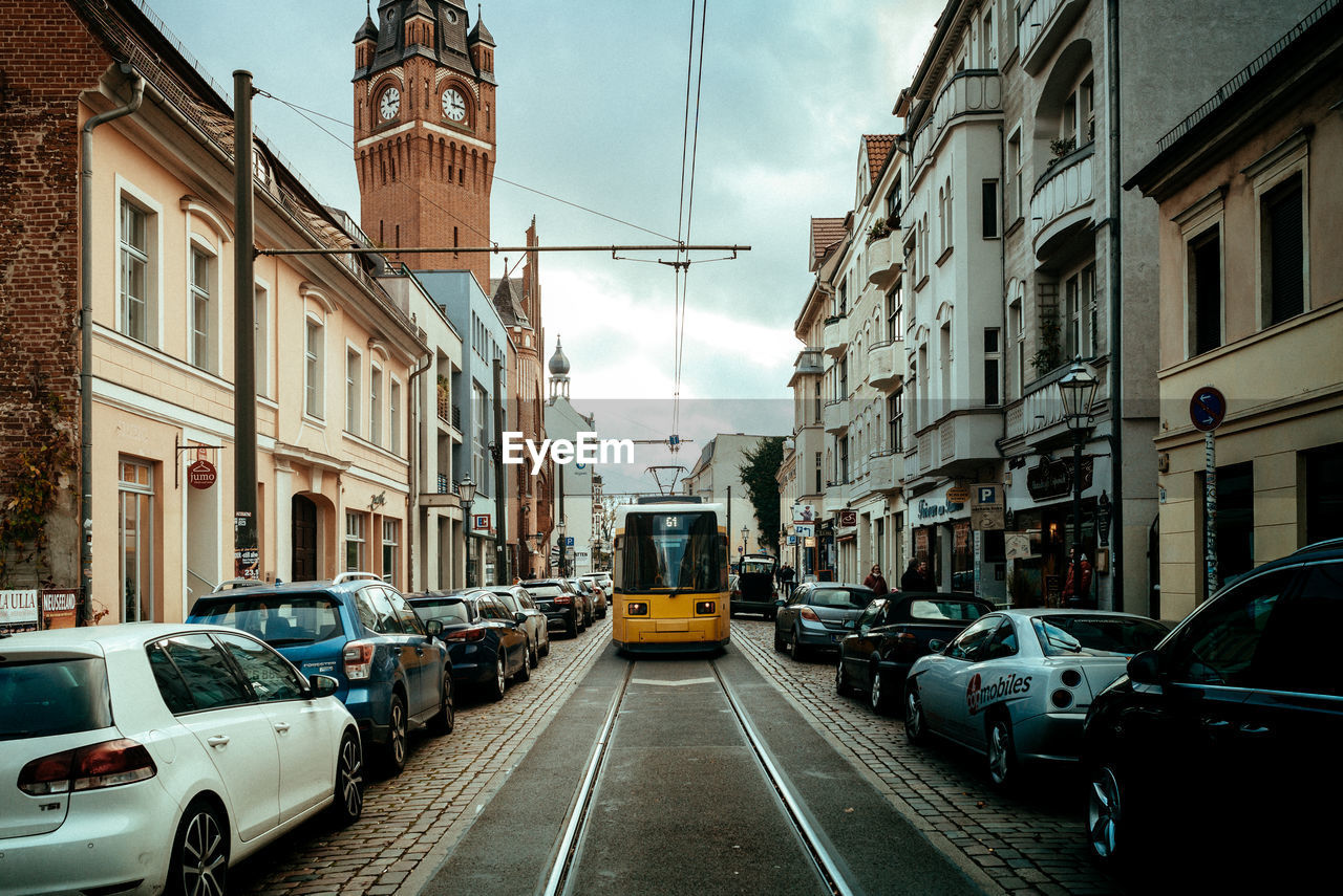 VEHICLES ON ROAD ALONG BUILDINGS