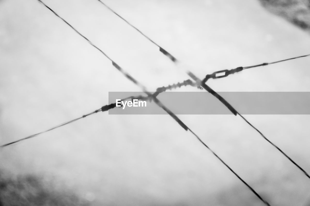 CLOSE-UP OF BARBED WIRE AGAINST SKY