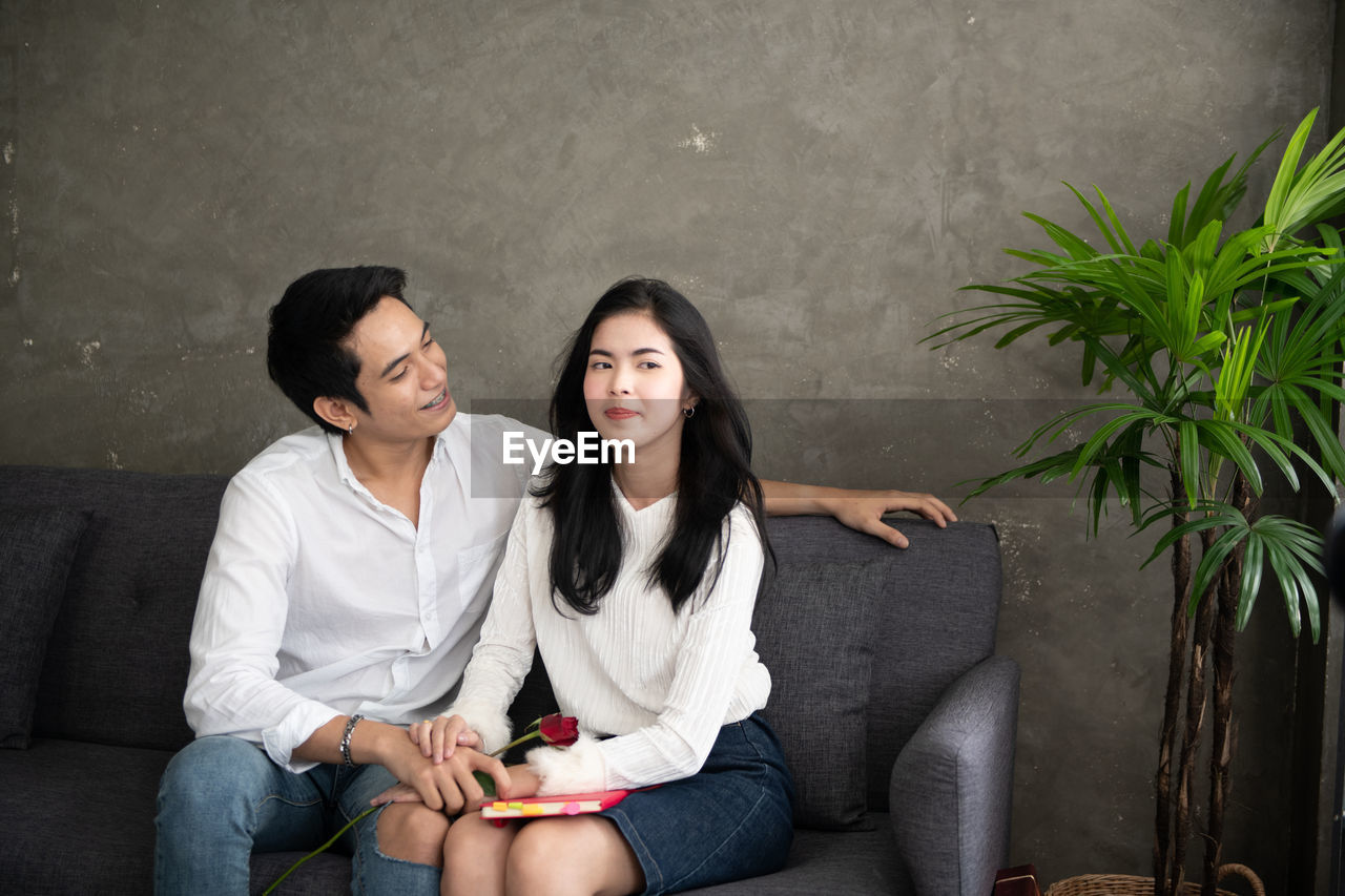 Young couple sitting on sofa at home