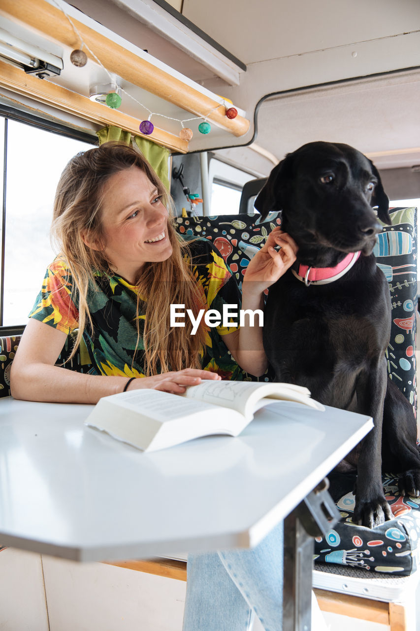 Woman traveling with dog in camper van