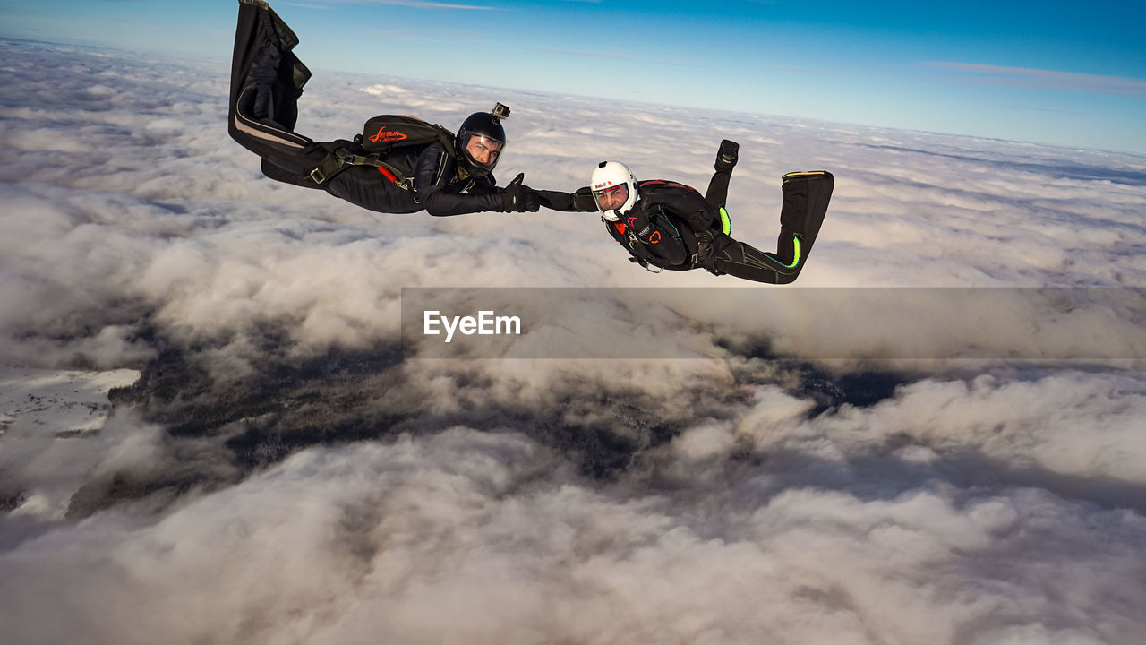 sky, nature, motion, mid-air, cloud, sports, flying, aerial view, adult, transportation, joy, communication, adventure, extreme sports, leisure activity, men, one person, environment, exhilaration, air vehicle, skydiving, day, outdoors, stunt, air sports, parachuting, airplane, warning sign, mode of transportation, windsports, sign, speed, risk, full length, activity