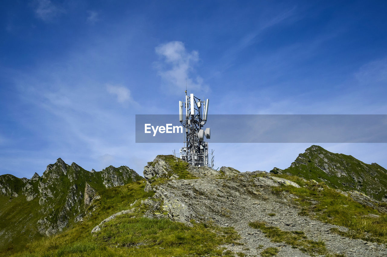Metal tower with various telecommunication antennas on top of a mountain. copy space 