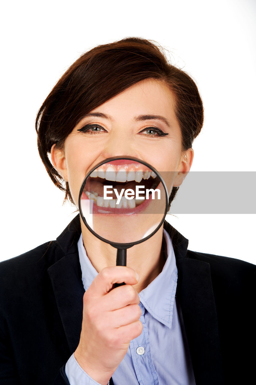 Laughing businesswoman holding magnifying glass