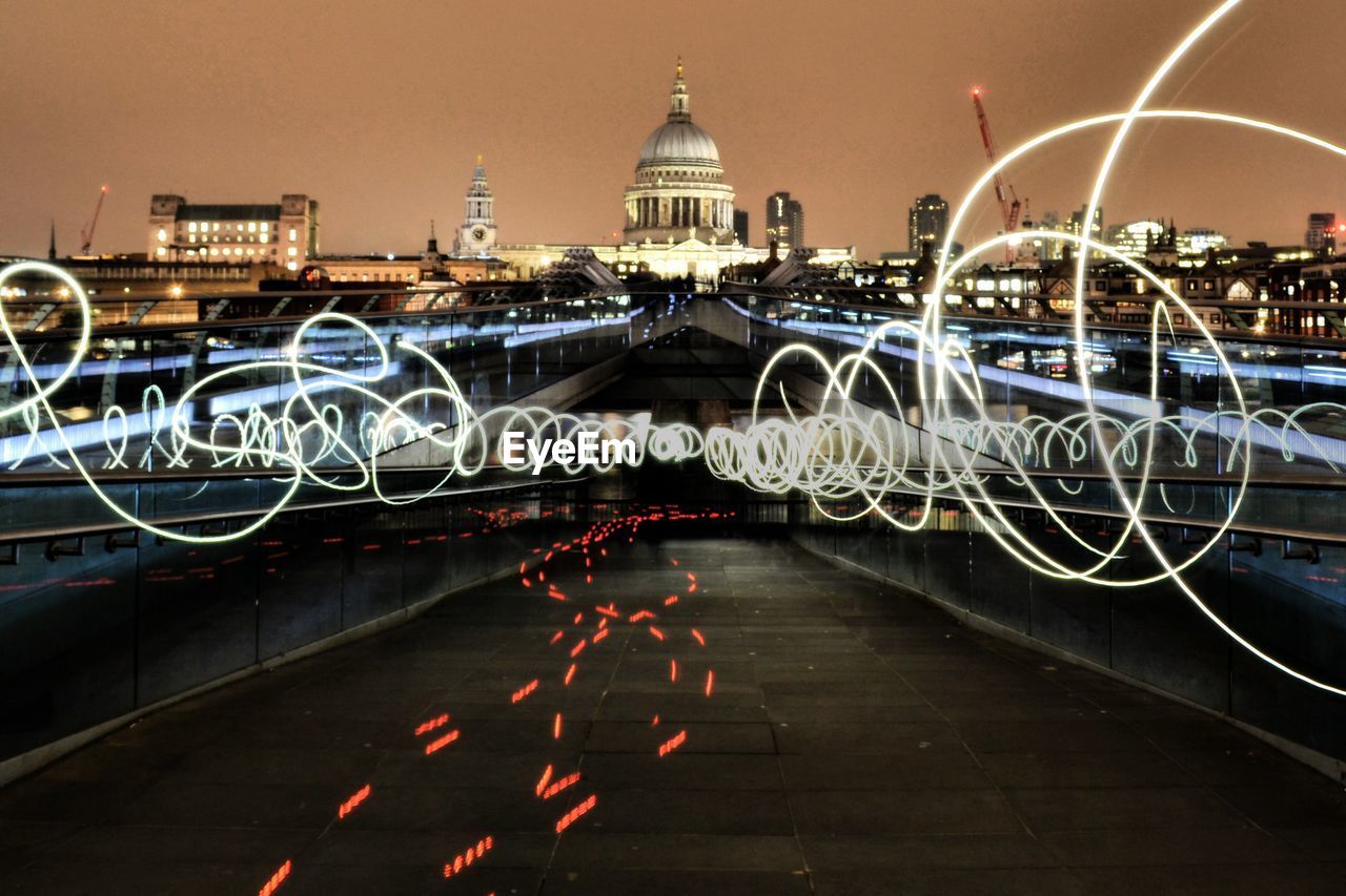 Light paintings on bridge against illuminated st paul cathedral at night