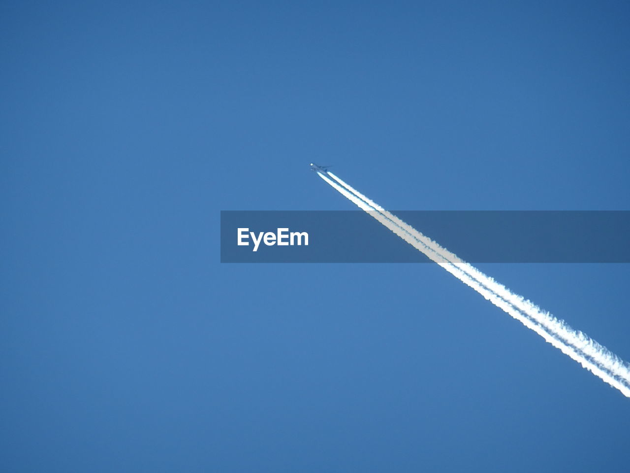 LOW ANGLE VIEW OF AIRPLANE AGAINST CLEAR BLUE SKY