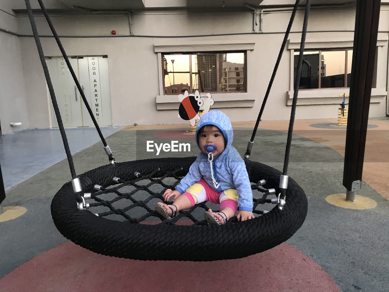 Full length of boy sitting in swing