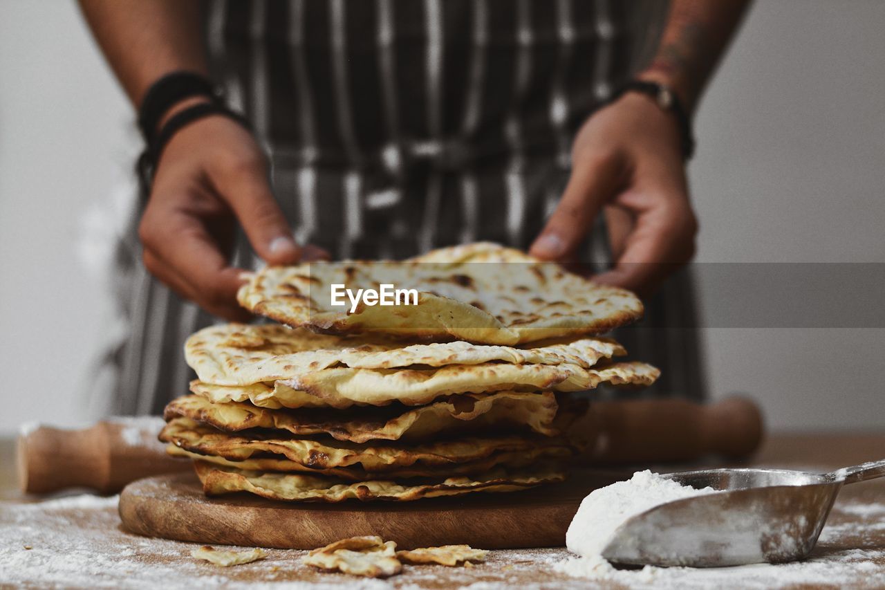 Midsection of person holding flat bread