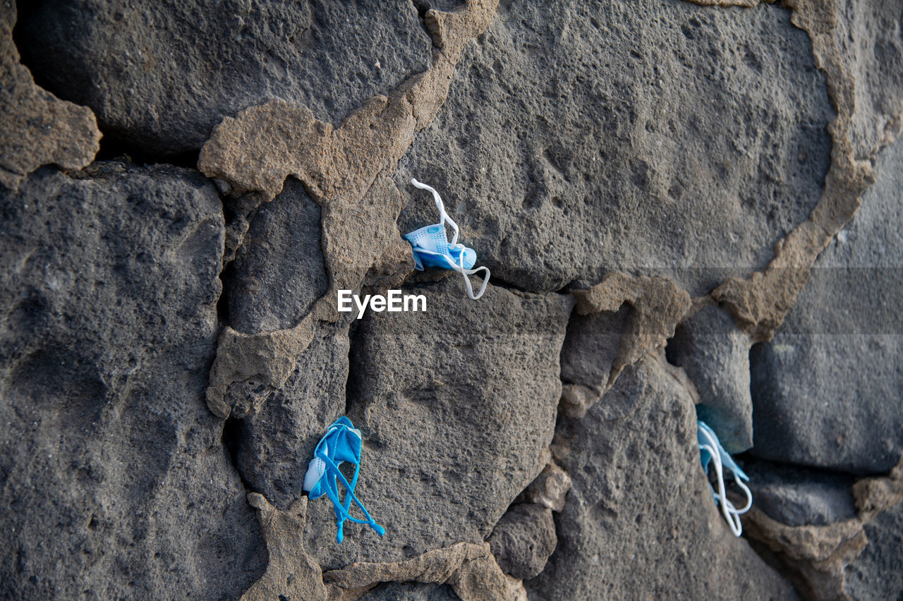 Masks stuck by tourists in the cracks on the cliff of playa de las canteras las palmas de gran