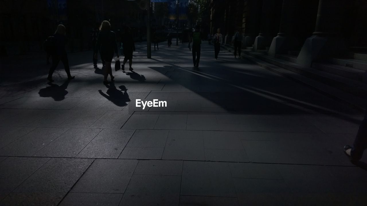 Silhouette people walking on street at night