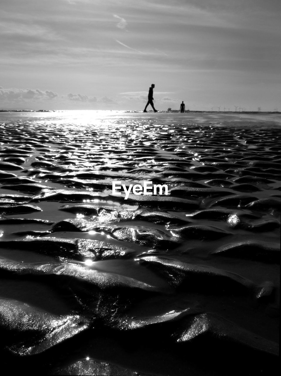 SILHOUETTE OF PERSON ON BEACH AGAINST SKY