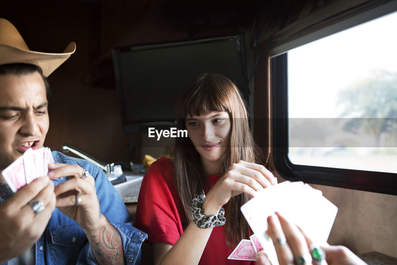 Couple playing cards while travelling in camper van