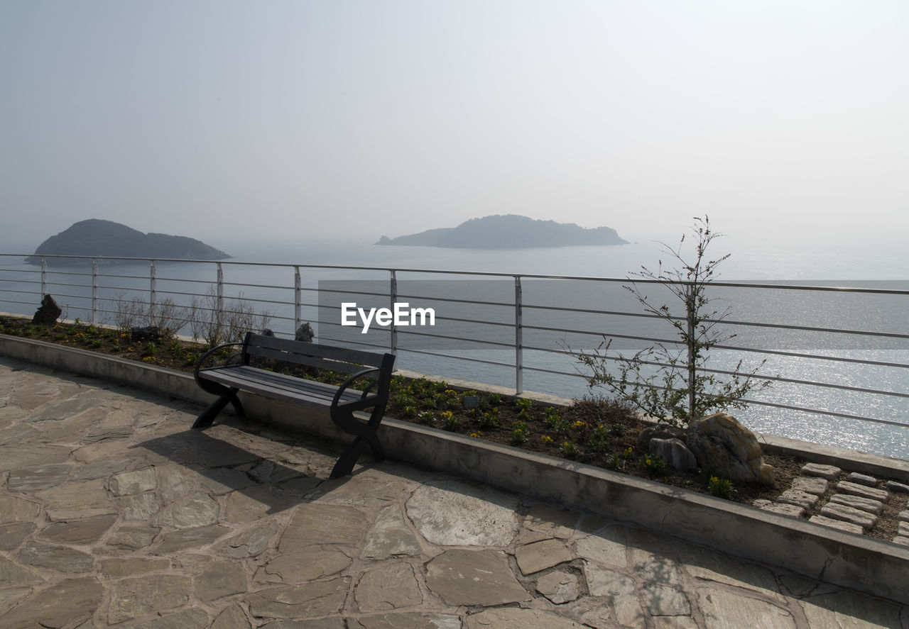 Empty bench by sea