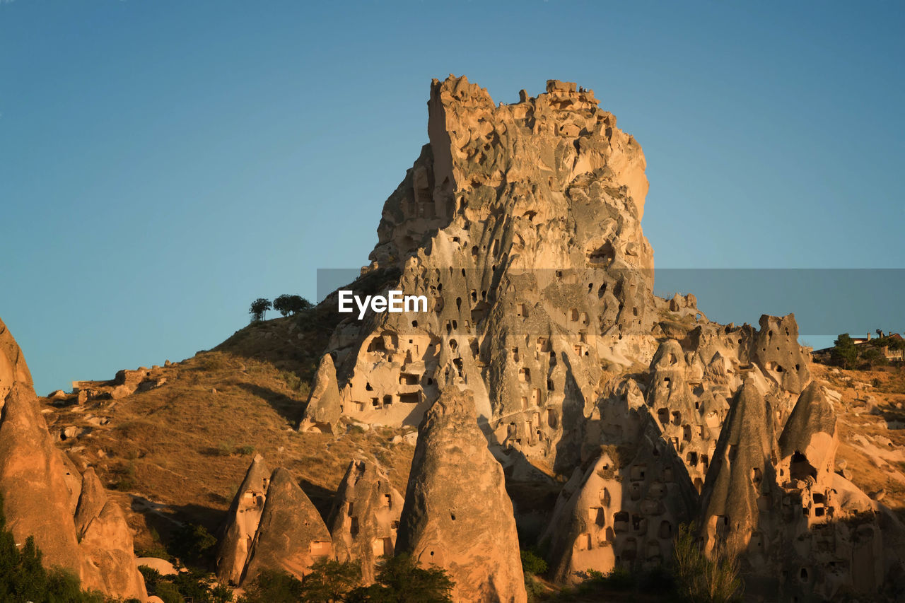 Low angle view of rocky mountain against clear sky