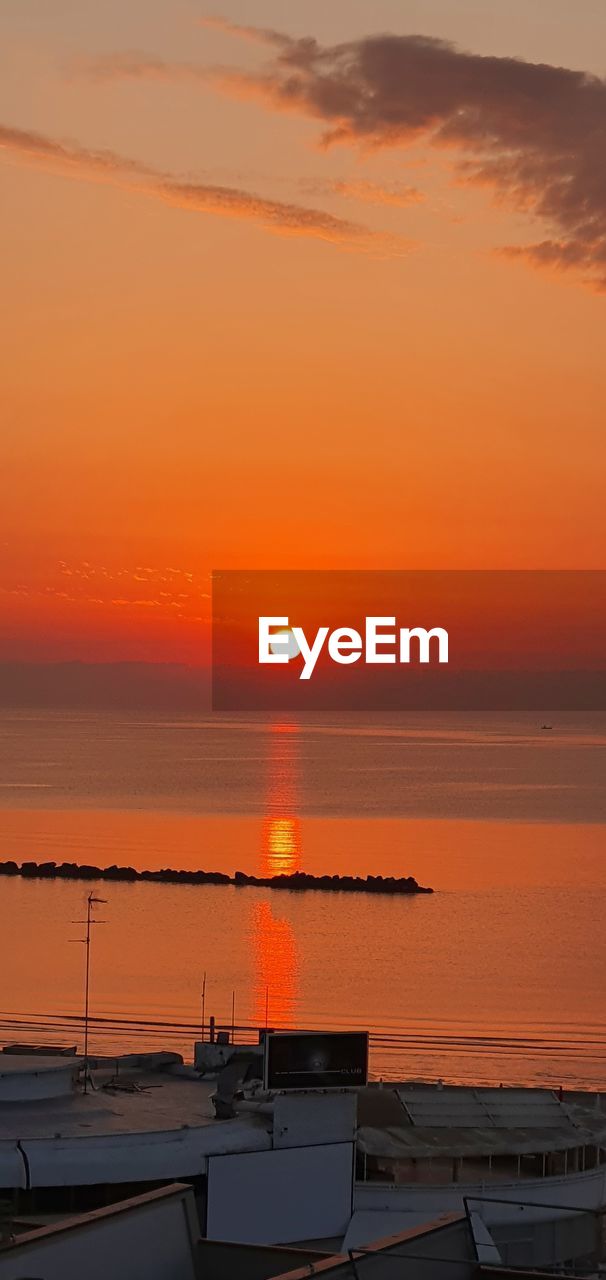 Scenic view of sea against orange sky