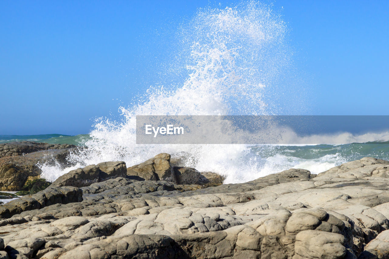 WAVES BREAKING AGAINST CLEAR SKY