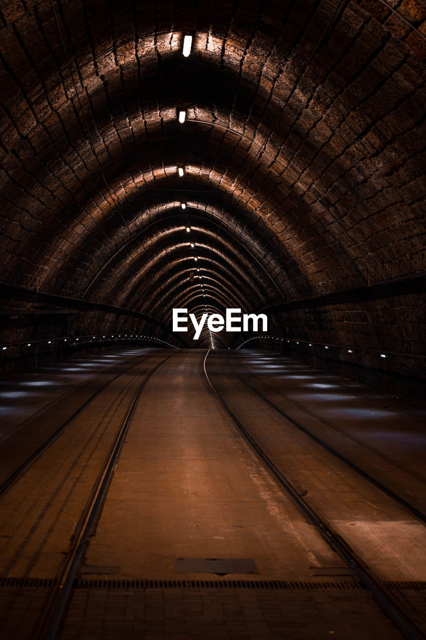 Illuminated railroad tracks in tunnel