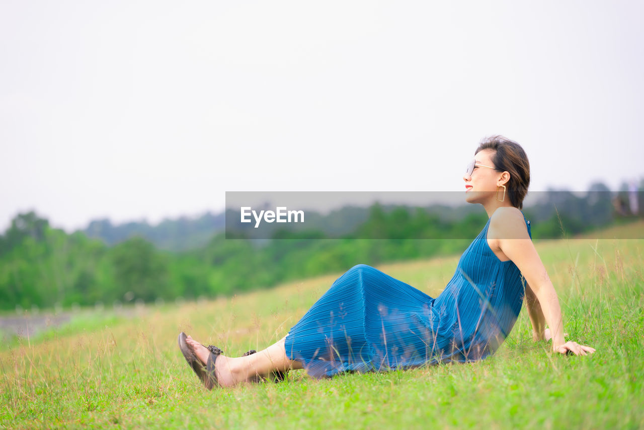 Side view full length of woman relaxing on land