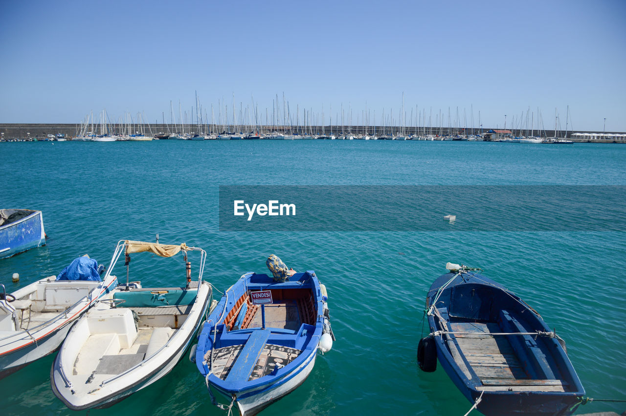 water, nautical vessel, transportation, sea, mode of transportation, vehicle, architecture, nature, sky, boat, blue, travel destinations, moored, travel, clear sky, no people, day, built structure, harbor, ship, building exterior, city, watercraft, pier, outdoors, marina, tourism, bay, tranquility, boating, sunlight, sunny, scenics - nature, beauty in nature, waterfront, land, dock, tranquil scene