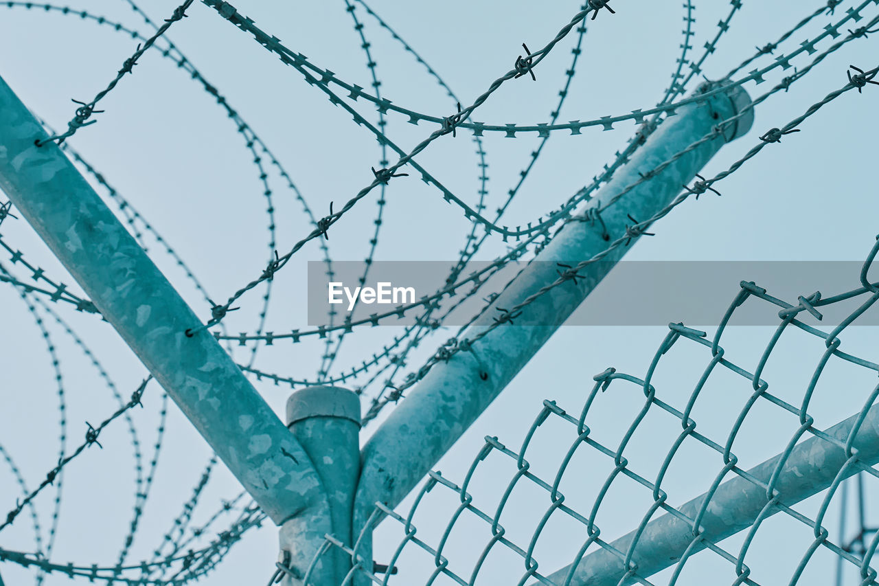 LOW ANGLE VIEW OF BARBED WIRE AGAINST SKY