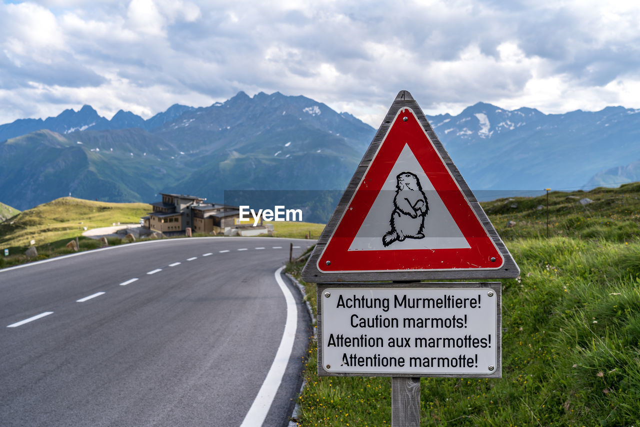 ROAD SIGN AGAINST MOUNTAIN RANGE
