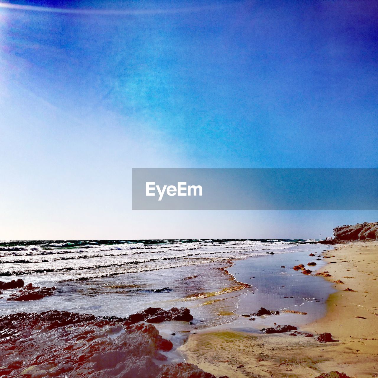 Scenic view of beach against blue sky