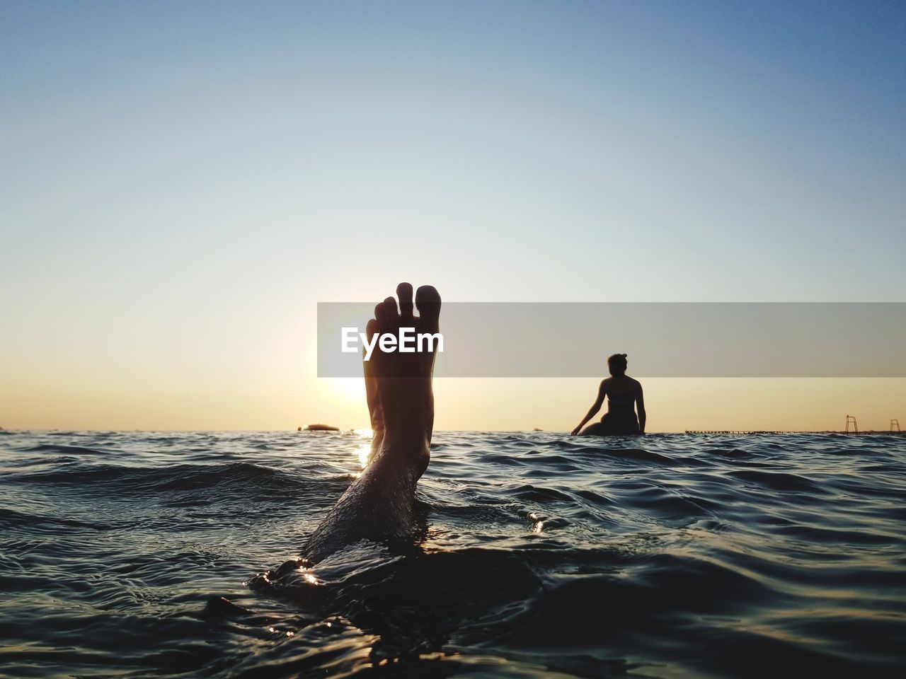 SILHOUETTE MAN SURFING IN SEA AGAINST SKY DURING SUNSET