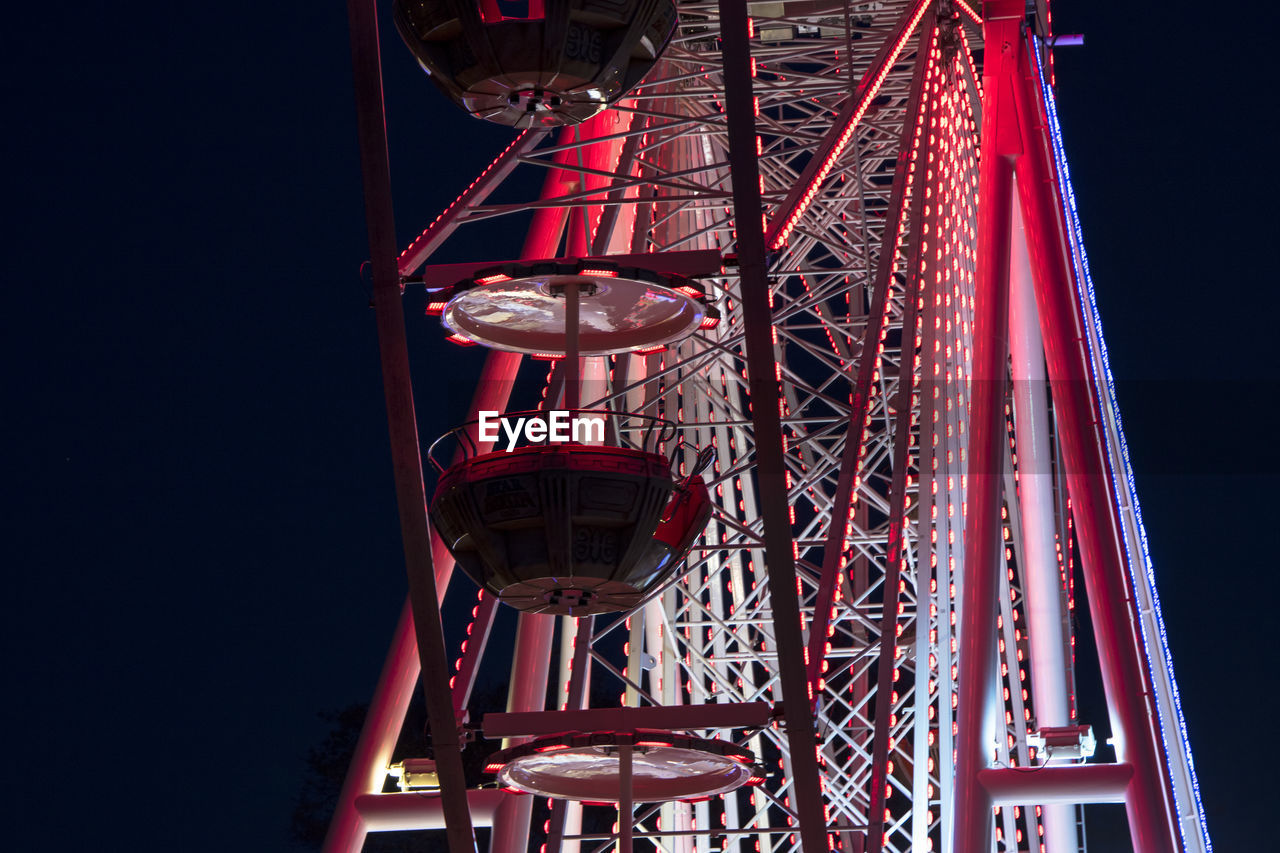 Low angle view of illuminated ferris wheel against sky at night