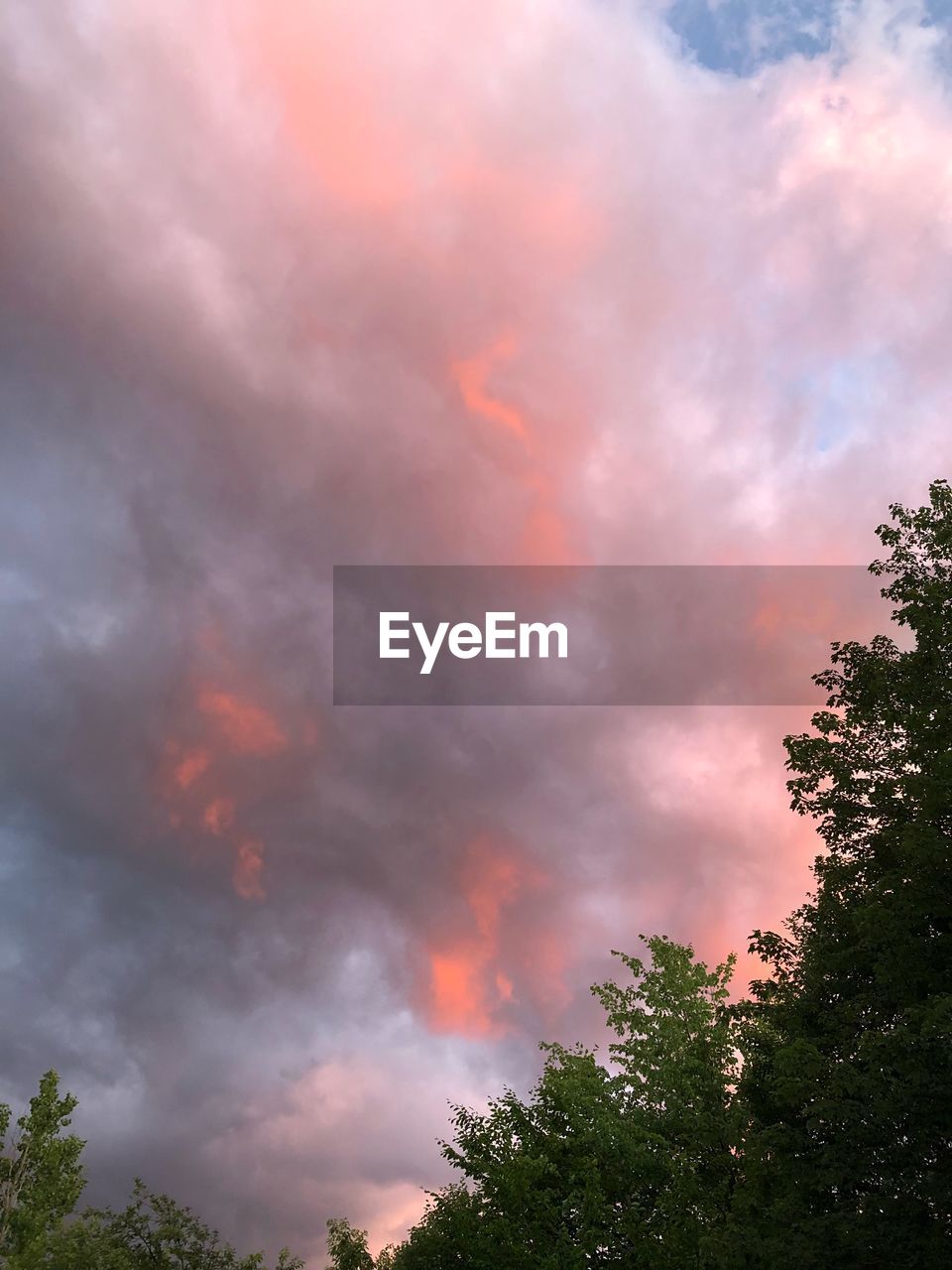 LOW ANGLE VIEW OF RAINBOW AGAINST SKY AT SUNSET