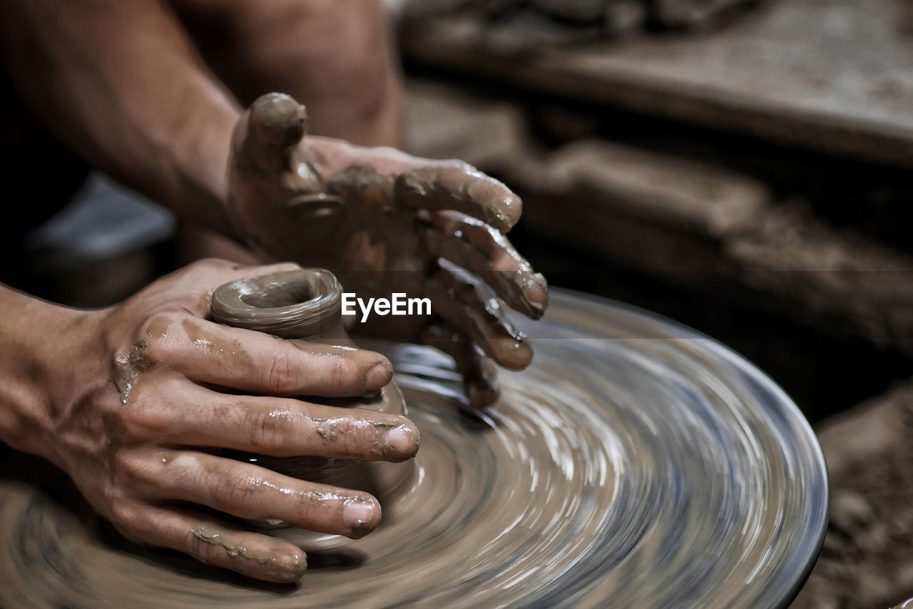 Midsection of person preparing food in mud