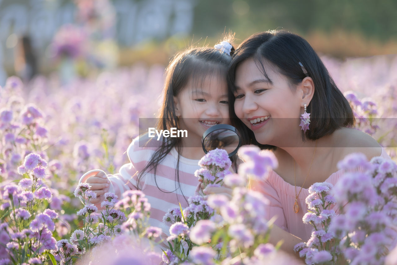 Close-up of mother and daughter by purple flowering plants