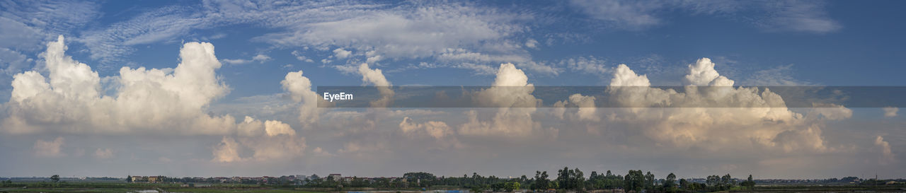 Panoramic view of trees and buildings against sky