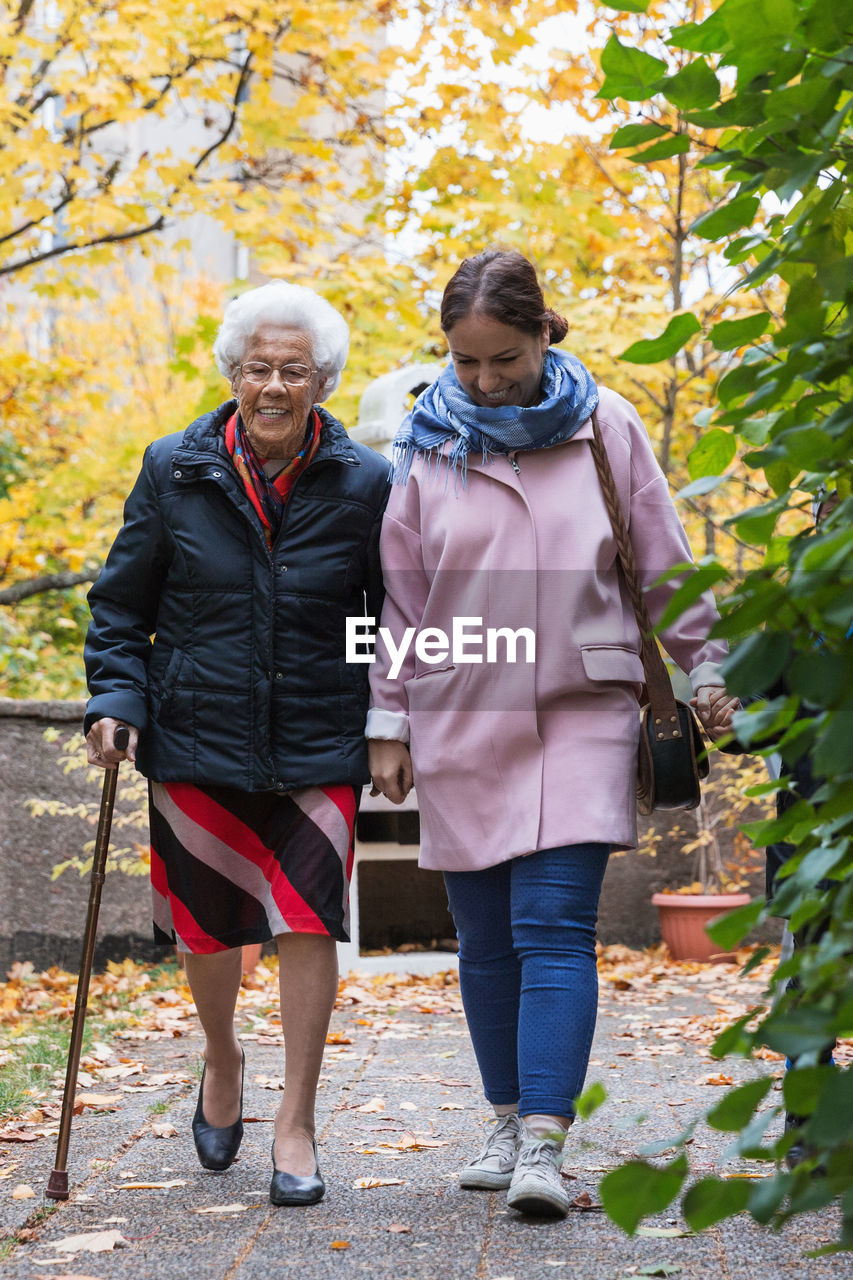 Full length of senior woman walking with daughter in park