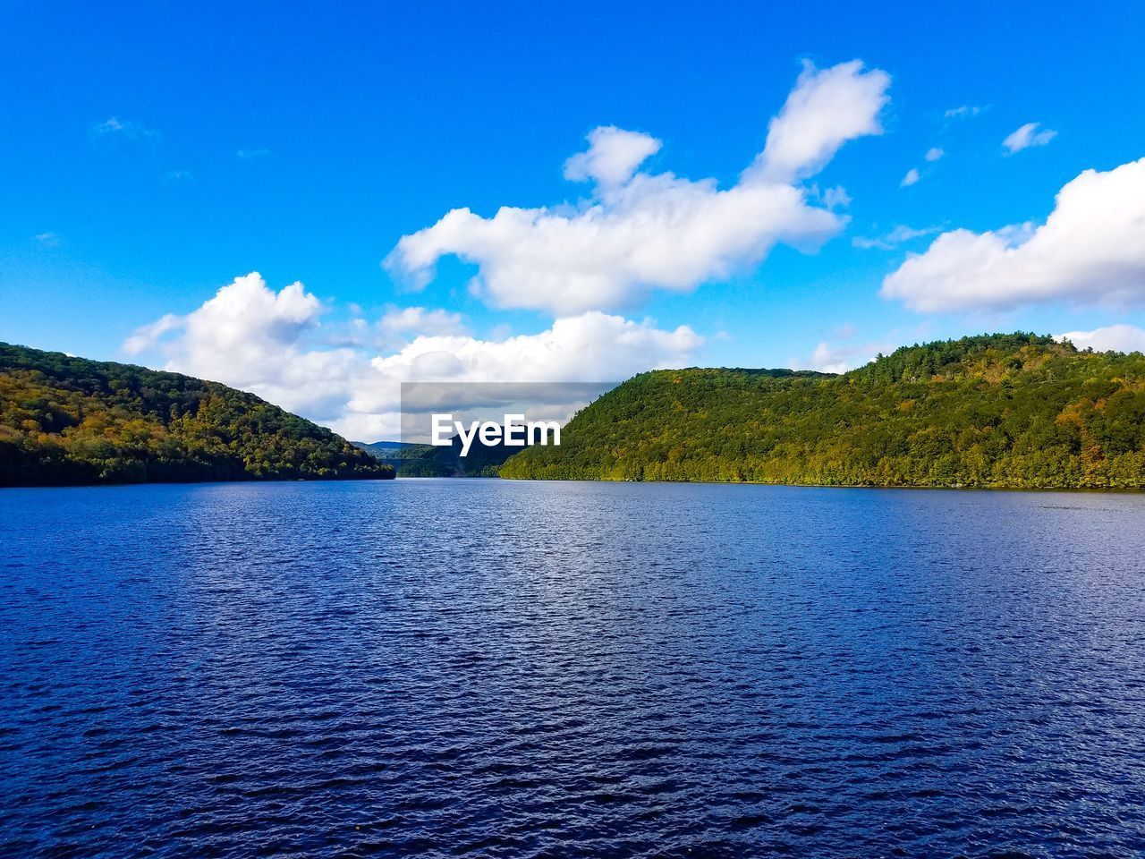 SCENIC VIEW OF SEA AND MOUNTAINS AGAINST BLUE SKY