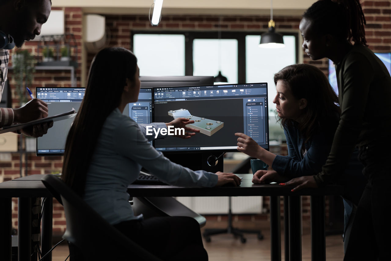 Businesswoman with colleagues discussing work at office