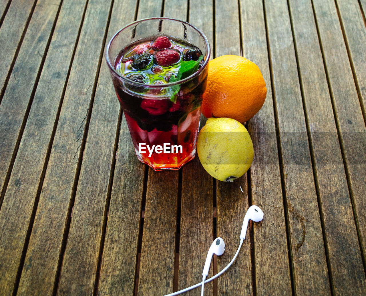 Directly above shot of glass with raspberry on wooden table