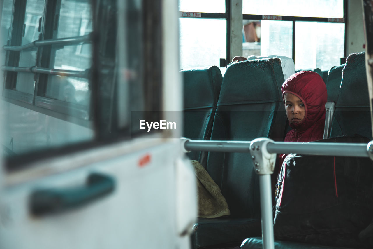 Portrait of a boy looking through window