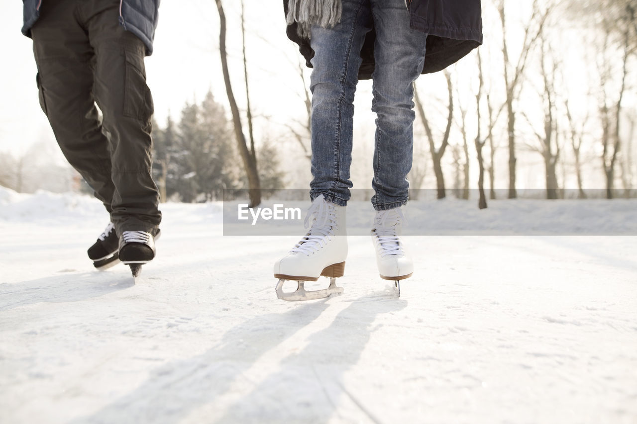 Close-up of two ice skaters on frozen lake