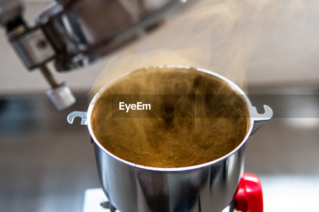 food and drink, coffee, drink, mug, cup, coffee cup, refreshment, appliance, indoors, food, hot drink, close-up, heat, freshness, coffeemaker, kitchen utensil, cafe, focus on foreground, household equipment, no people, metal, steam, kitchen, domestic room, pouring, business, espresso maker