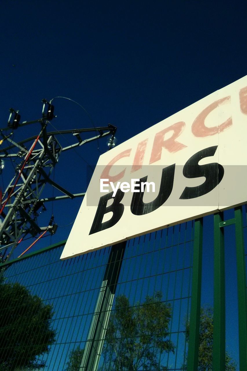 Low angle view of information sign against clear blue sky