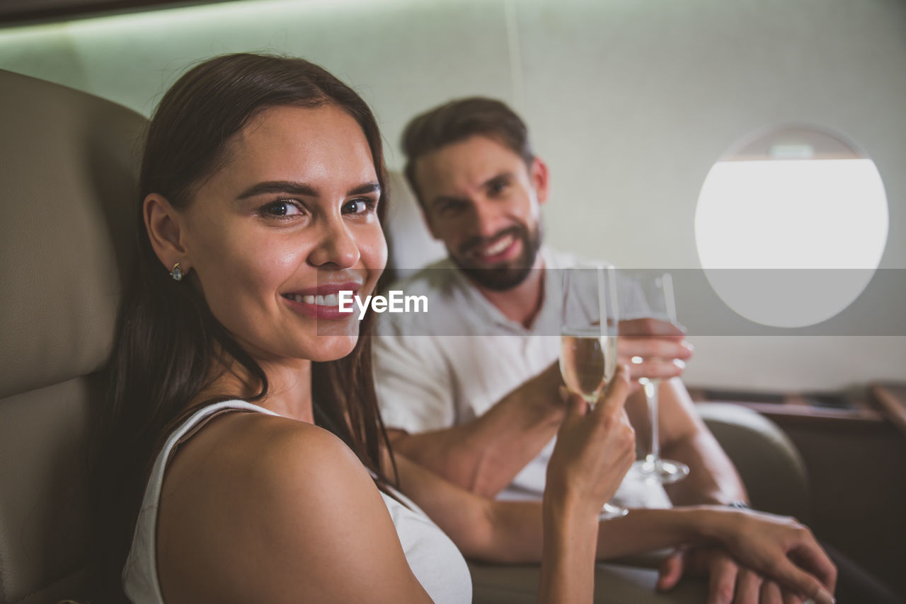 Portrait of couple drinking champagne in corporate jet